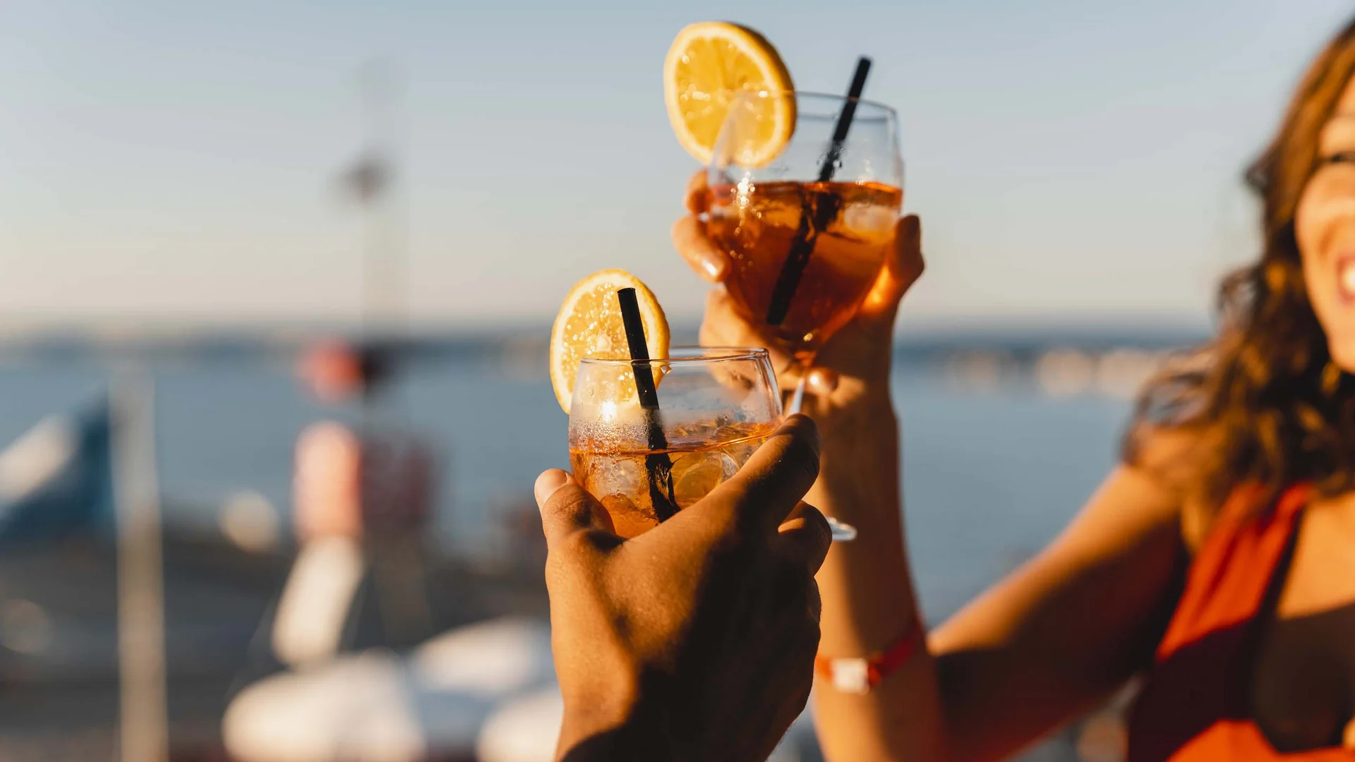 Le specialità culinarie delle Marche e del NVR Persone che brindano con cocktail decorati con fette di limone su sfondo mare