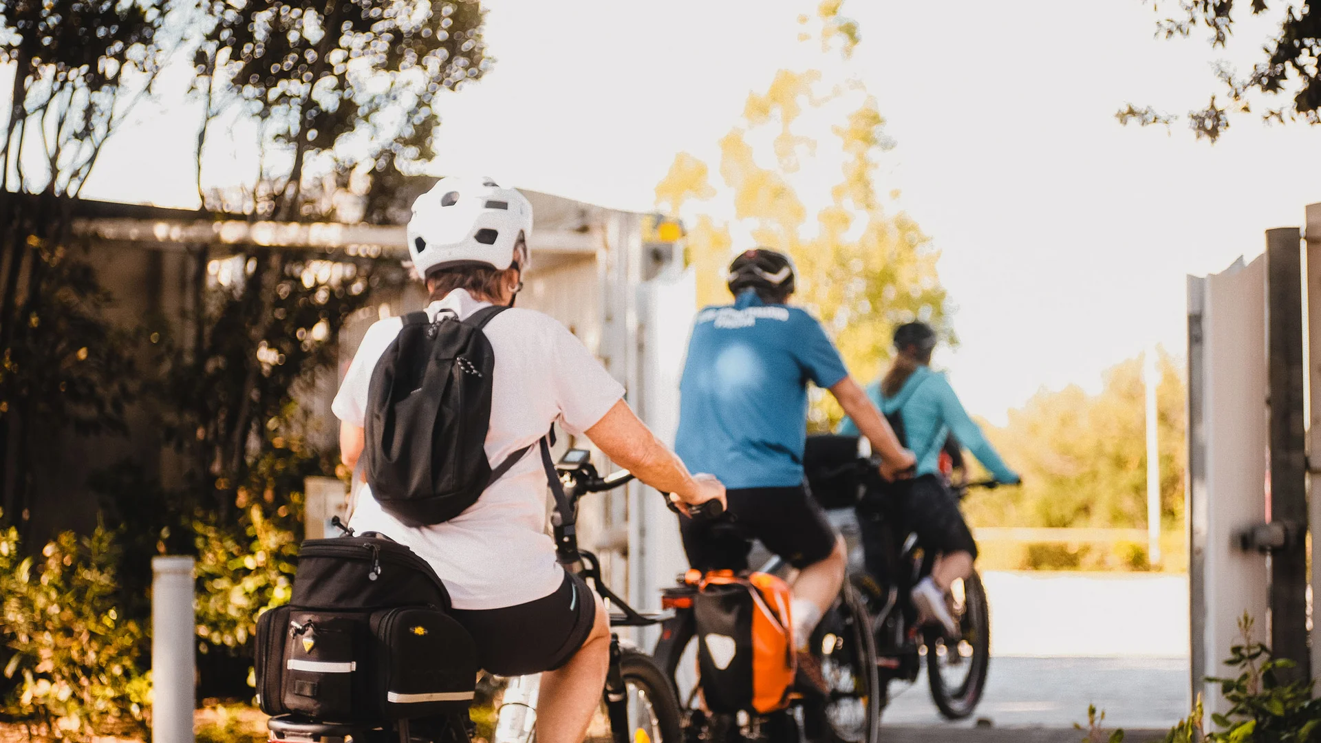 Vacanza in e-bike nelle Marche Persone in bici con caschi e zaini in ambiente soleggiato