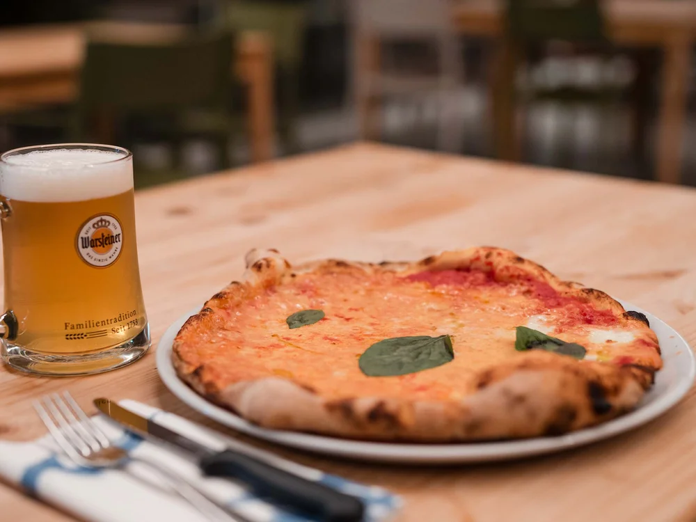 Garden Restaurant: uno dei ristoranti del nostro resort Pizza margherita con foglie di basilico e birra chiara in un boccale