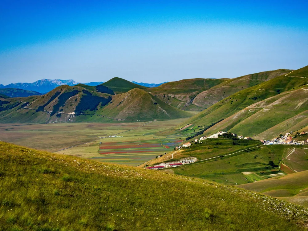 Il Parco Regionale del Conero e non solo Paesaggio montano verde con villaggio e cielo azzurro