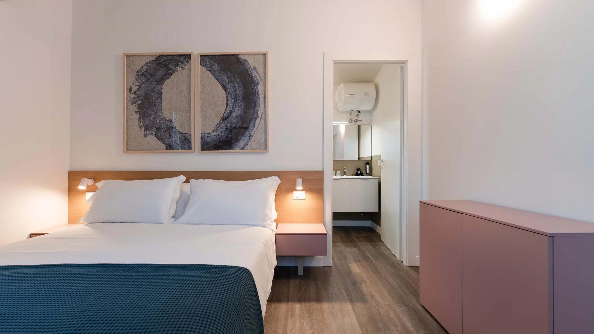 Benvenuti nel nostro resort al Conero Camera da letto moderna con letto matrimoniale, bagno e creativa decorazione a parete