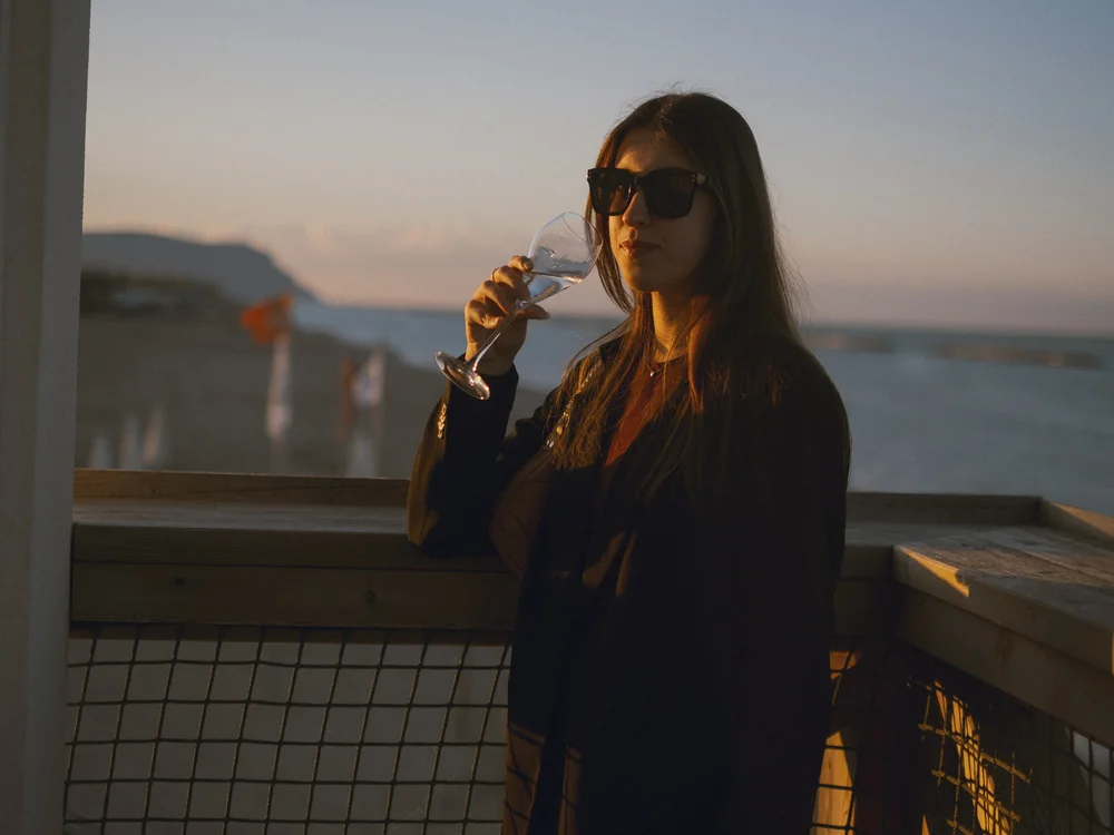 Gli eventi al Natural Village Resort Donna con occhiali da sole che beve da un bicchiere sulla terrazza al tramonto