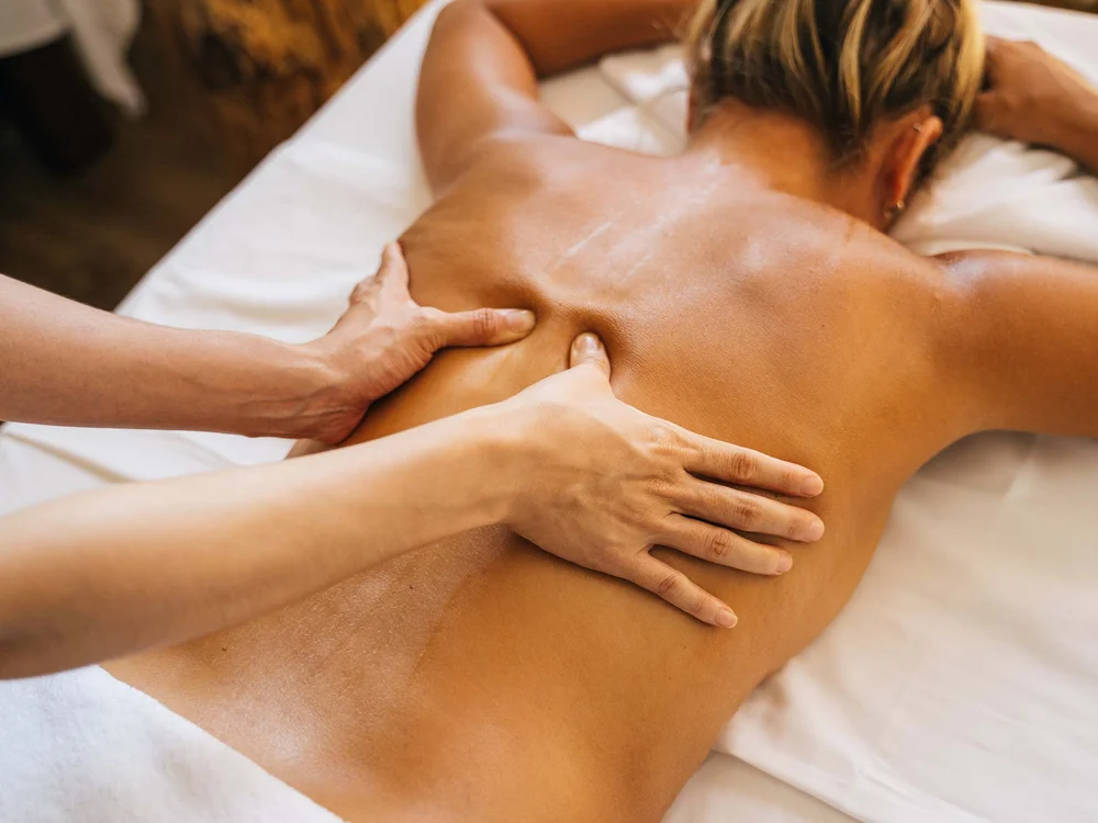 Resort al mare: pronti per un’escursione sul Conero? Massaggio alla schiena su una donna sdraiata sul lettino