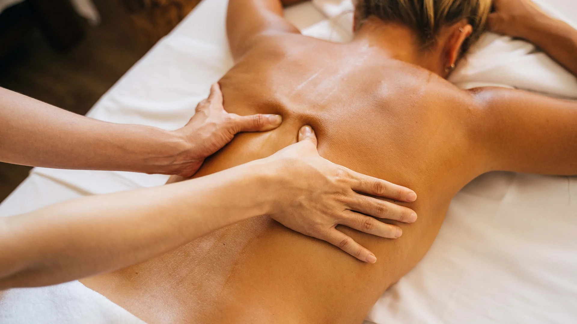 Una spa vicino a Porto Potenza Picena Massaggio alla schiena su una donna sdraiata sul lettino