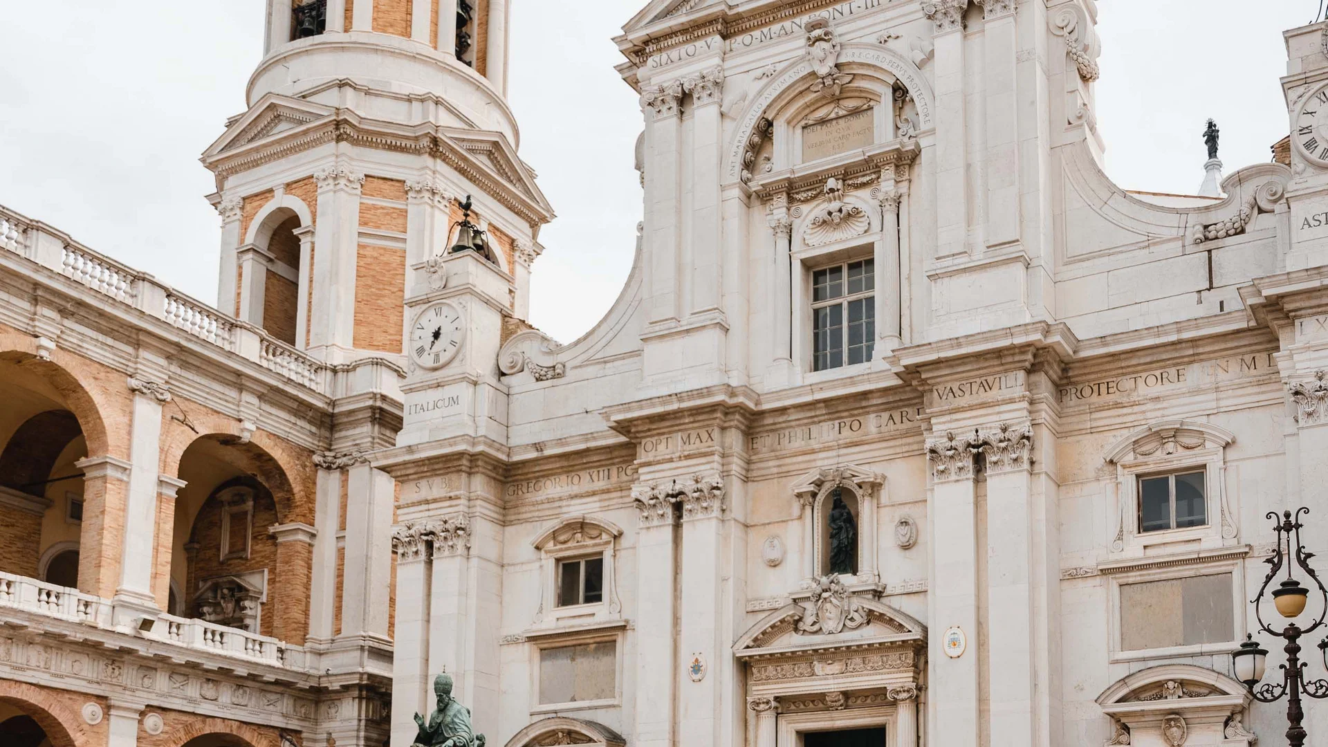 Cosa vedere nei dintorni del Natural Village Resort Coppia passeggia davanti a una chiesa storica con torre e statua