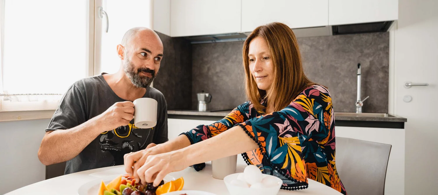 Un weekend romantico nelle Marche Coppia che fa colazione con frutta fresca e bevande nella cucina moderna