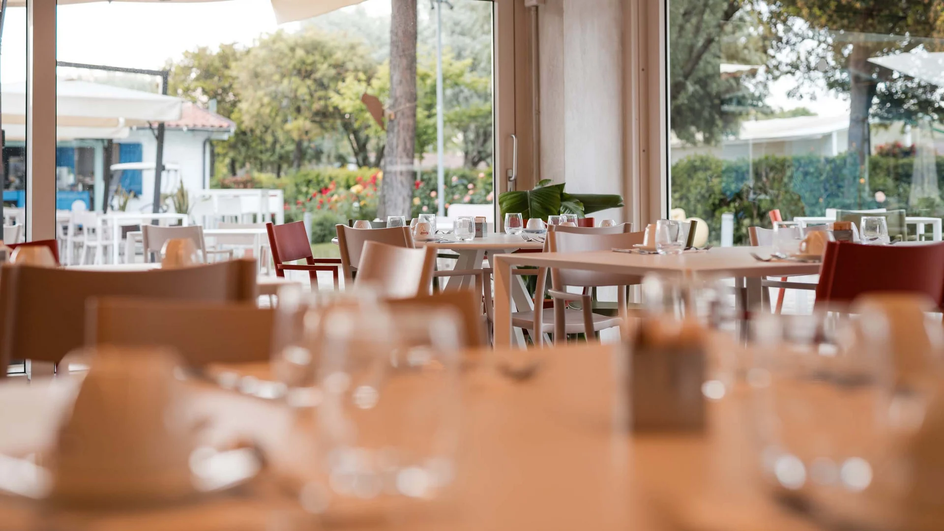 Garden Restaurant: uno dei ristoranti del nostro resort Interno di ristorante con tavoli apparecchiati e vista sul giardino