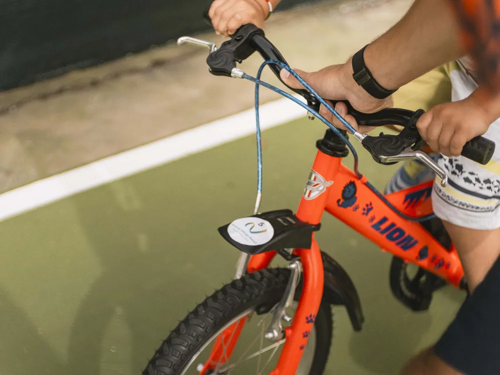 Un family hotel al Conero? Meglio un resort! Bambino impara a andare in bici con l'aiuto di un adulto