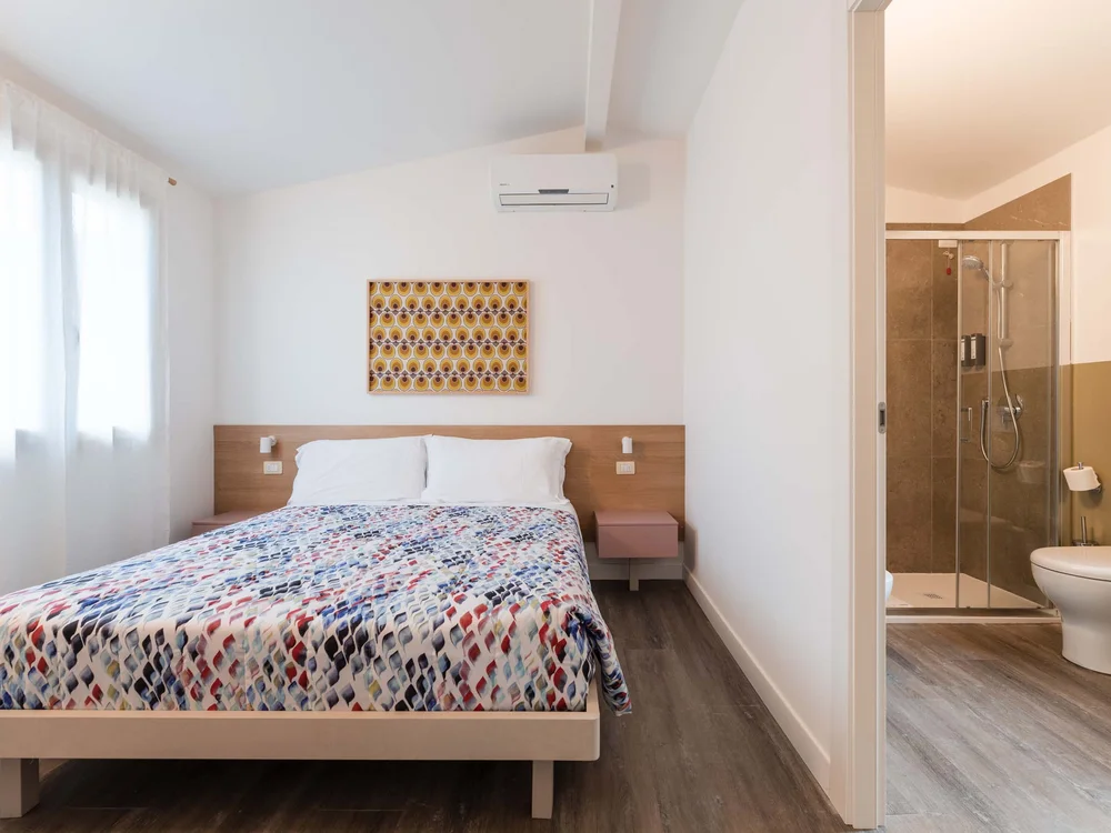 Benvenuti nel nostro resort al Conero Camera da letto moderna con letto matrimoniale e bagno con doccia