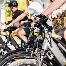 Vacanza in e-bike nelle Marche Persone giovani in sella a biciclette elettriche grigie allineate