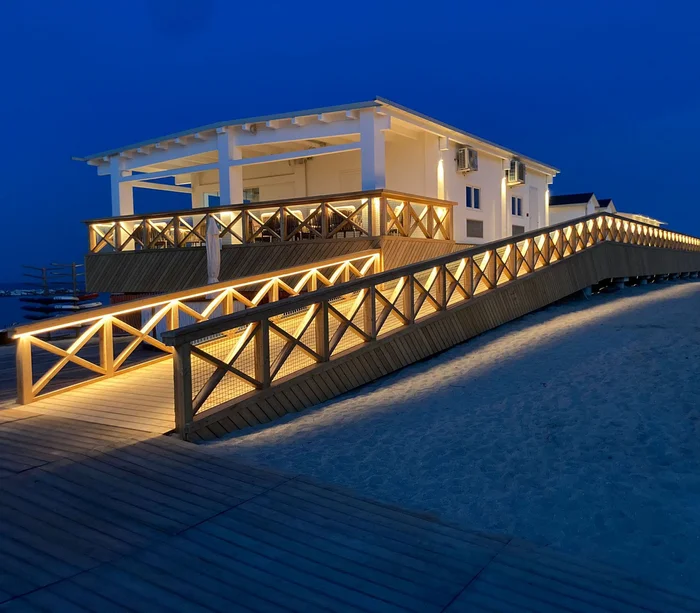 Una vacanza al mare sul Conero Rampa illuminata che conduce a edificio bianco sulla spiaggia di notte