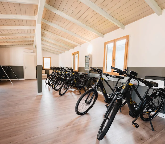 Vacanza in e-bike nelle Marche Interno di un edificio con fila di biciclette elettriche parcheggiate