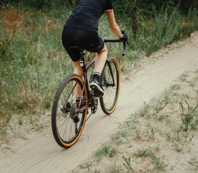 Una vacanza in gravel bike nelle Marche Ciclista con abbigliamento nero su strada di ghiaia in natura