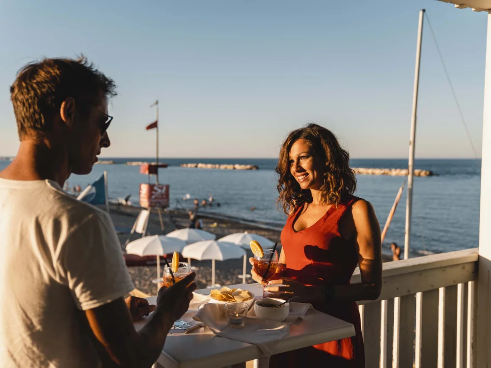 Un weekend romantico nelle Marche Coppia che si gode aperitivi al tramonto vicino al mare