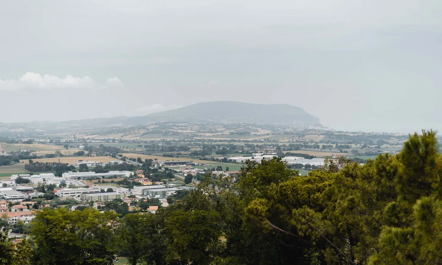 Resort al mare: pronti per un’escursione sul Conero? Veduta panoramica della campagna con colline, edifici e alberi verdi