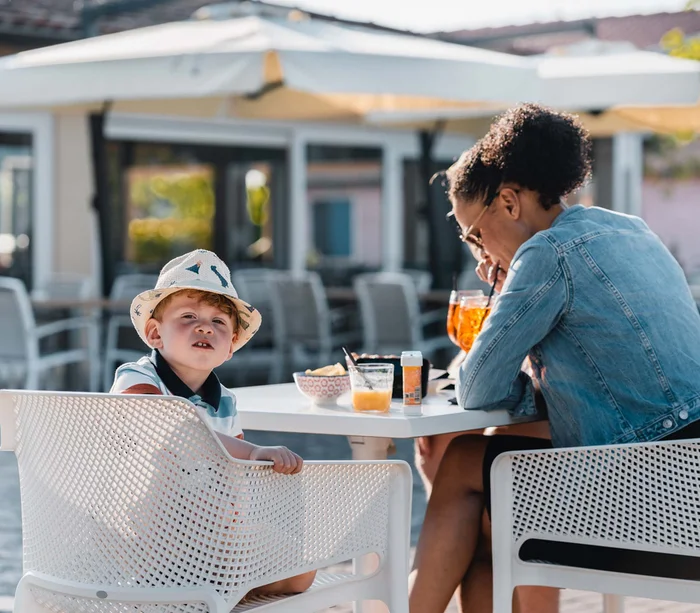Food truck & Pizzeria a Potenza Picena Bambino con cappello e donna seduti a un tavolo all'aperto con bevande