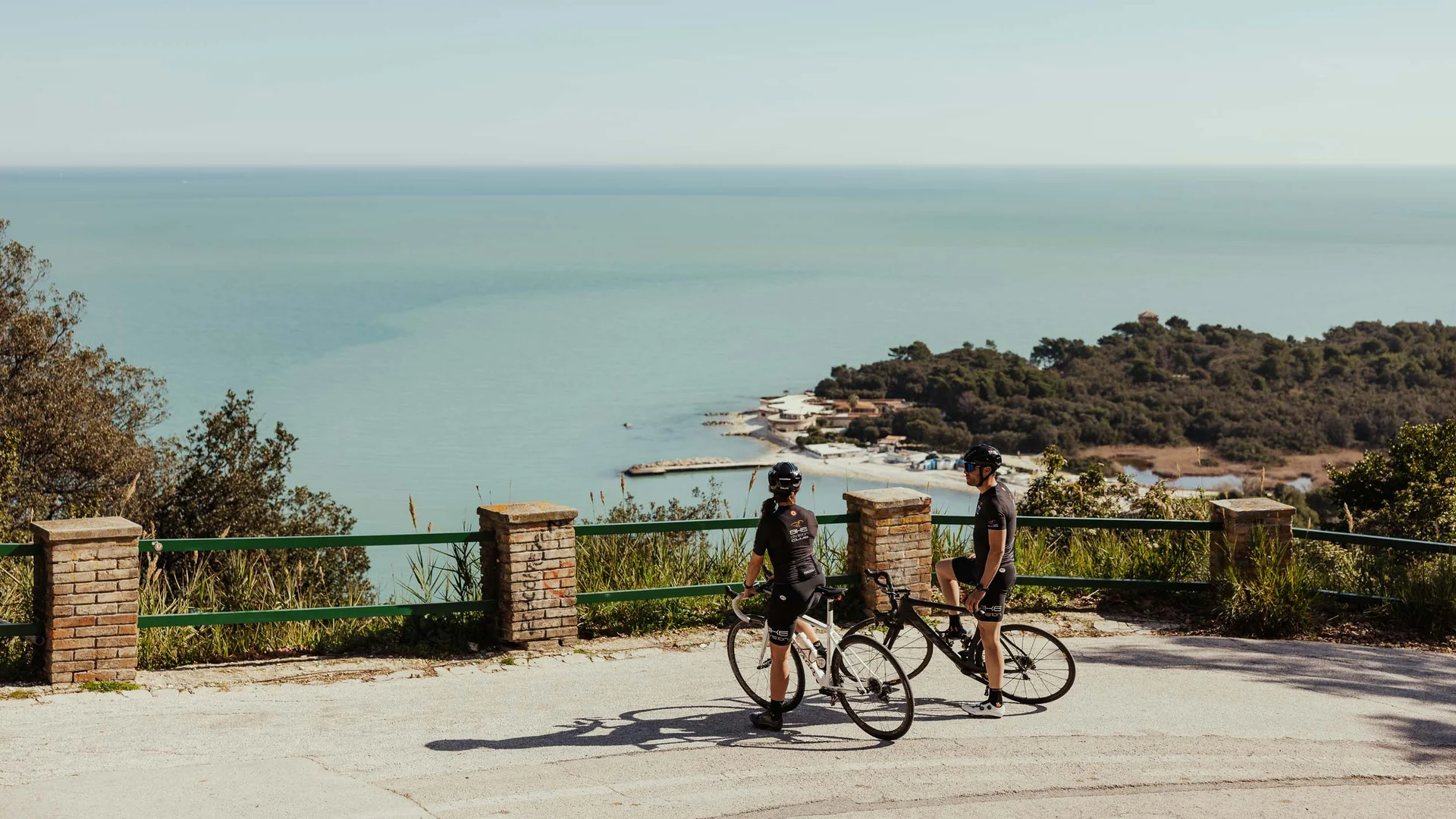 Un villaggio nelle Marche sul mare: il Natural Village Resort Ciclisti con biciclette guardano il mare da una strada panoramica