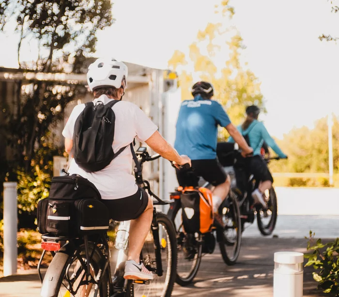 Un villaggio nelle Marche sul mare: il Natural Village Resort Persone in bici con caschi e zaini in ambiente soleggiato