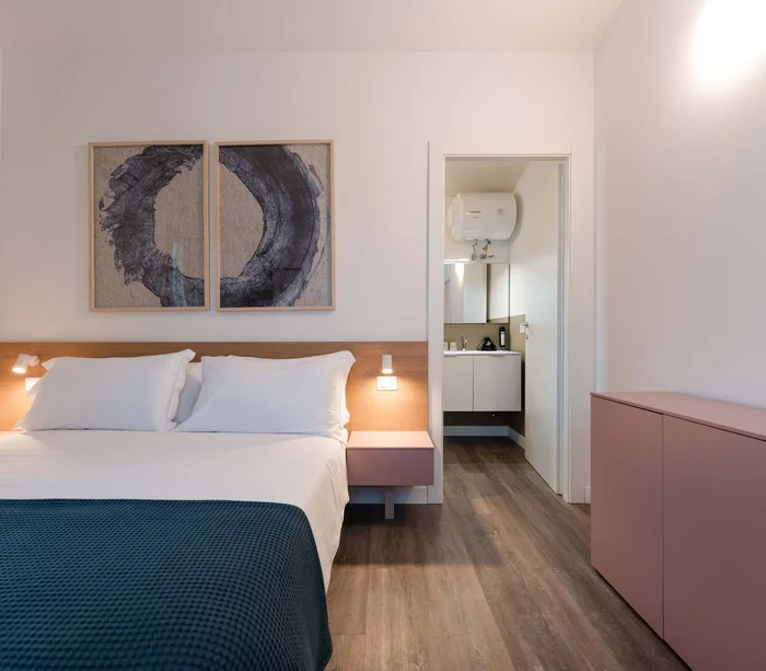 Un villaggio nelle Marche sul mare: il Natural Village Resort Camera da letto moderna con letto matrimoniale, bagno e creativa decorazione a parete