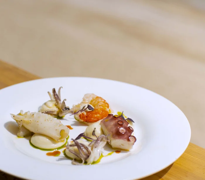 Un villaggio nelle Marche sul mare: il Natural Village Resort Piatto di frutti di mare con polpo, gambero e calamari su crema bianca