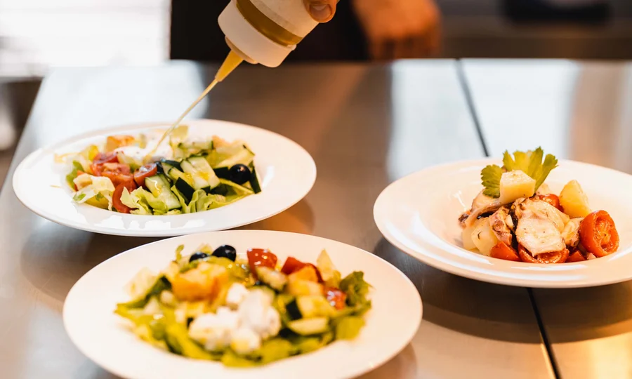 Seaside restaurant & lounge bar in the Marche region Fresh salads being dressed with oil from a squeeze bottle