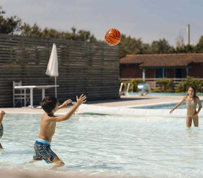 Un villaggio nelle Marche sul mare: il Natural Village Resort Bambini che giocano a pallanuoto in piscina all'aperto